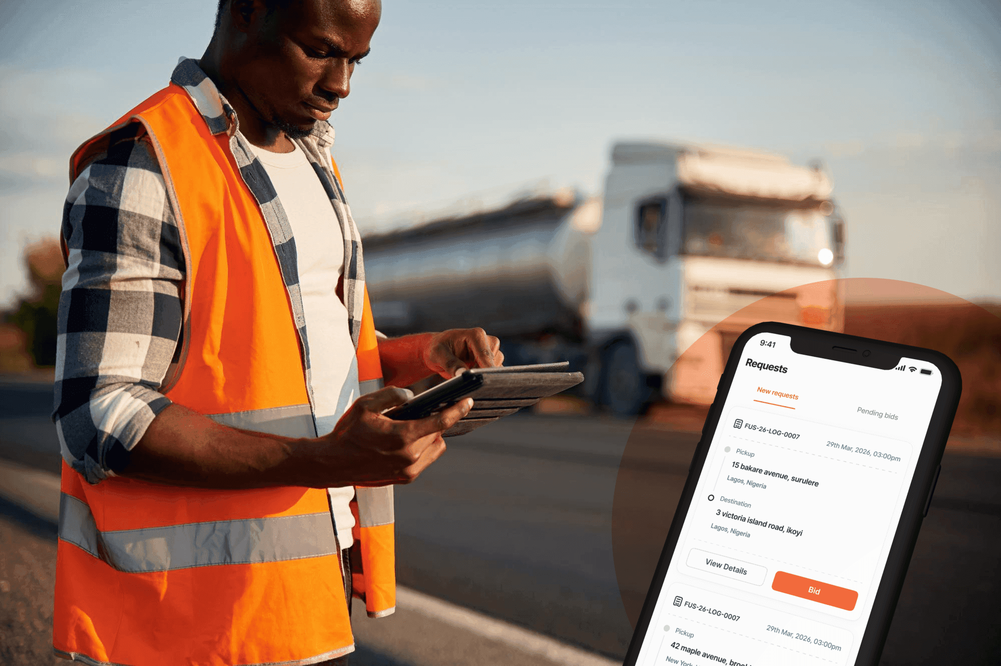 Transporter checking delivery requests on the Hauliin app beside a tanker truck